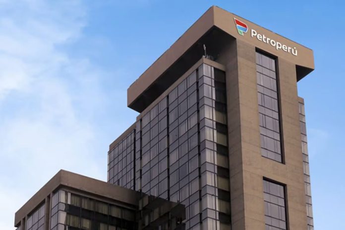 Tall modern office building with Petroperú signage at the top against a blue sky.