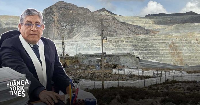 Man in a suit and scarf seated at a desk with papers, with a large open-pit mine in the background; Huanca York Times watermark in the corner.
