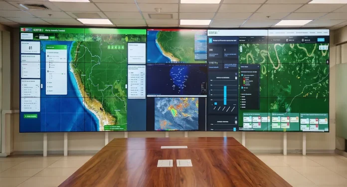 Multi-panel digital wall showing the SERFOR Forest Fire Alert dashboard with maps, charts and data panels in a conference room.