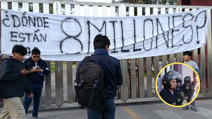 Group of young people by a metal gate under a white banner that reads '¿Dónde están? 8 millones' indicating a missing-people protest or call for attention to disappearances.